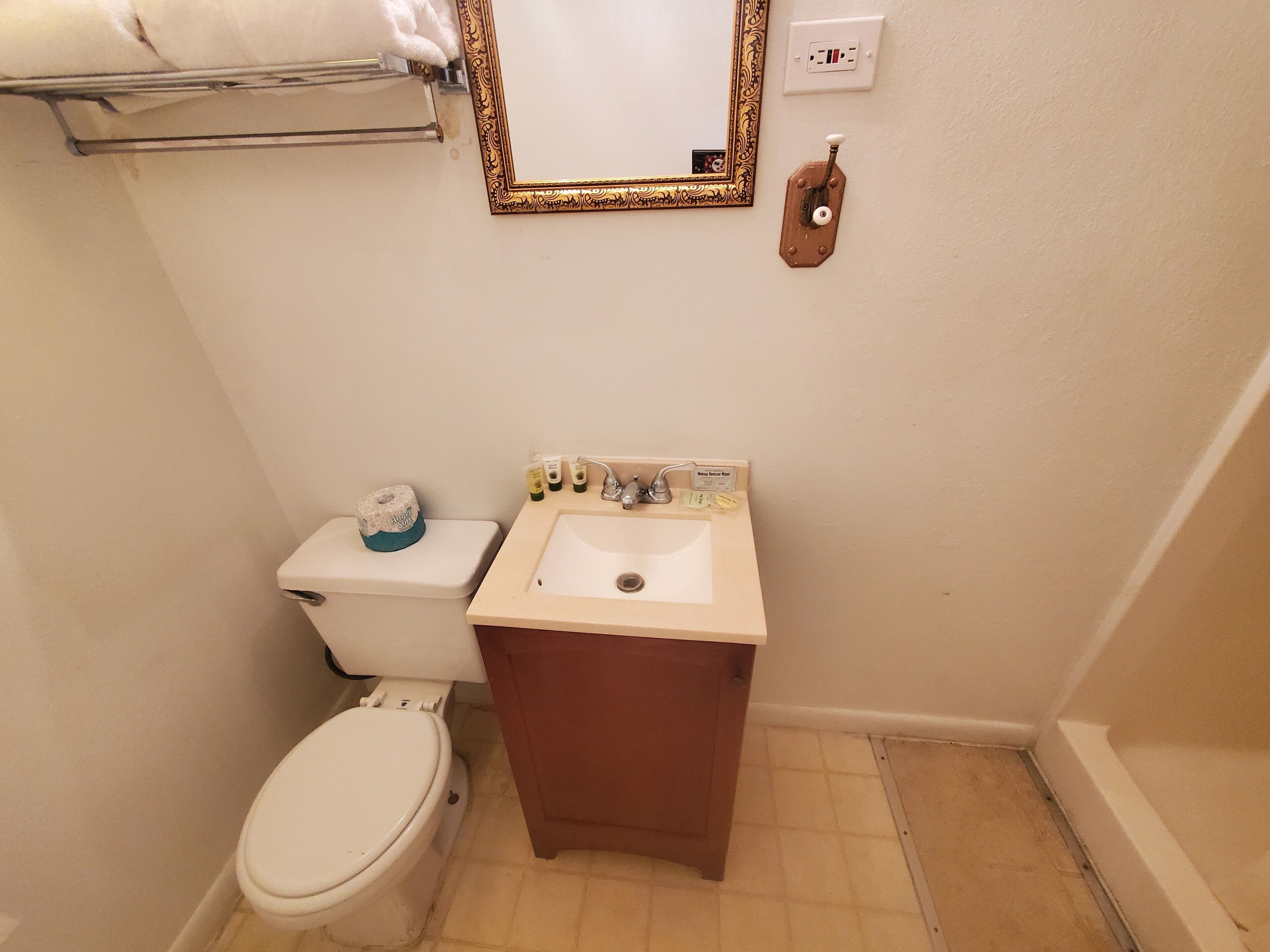 Une petite salle de bain avec des toilettes, un lavabo et un miroir.