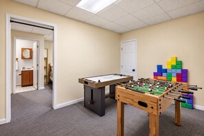 Game room from the doorway, with air hockey, foosball, and the block puzzle, and a bathroom across the hall.