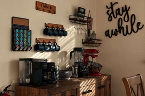 A kitchen counter with coffee and wine mugs, a coffee maker, a blender, and a red mixer. - Skyland Hideaway | Mountain Cabin w/ Hot Tub (Linden)