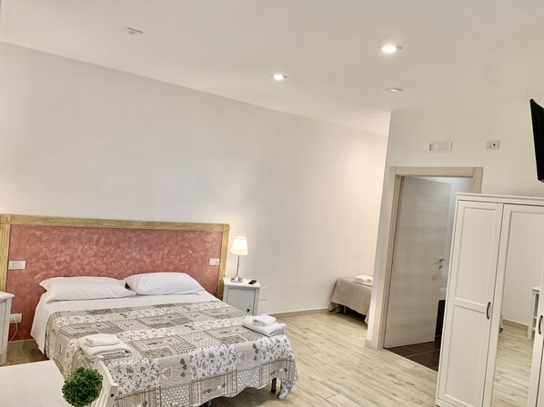 Relax in this inviting space with a large bed, bedside table, and wardrobe.