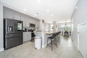 Enjoy cooking in this well-equipped kitchen with stainless steel appliances, ample counter space, and a central island with bar stools.