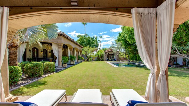 Ein Poolbereich mit Liegestühlen und Blick auf Pool und Garten.