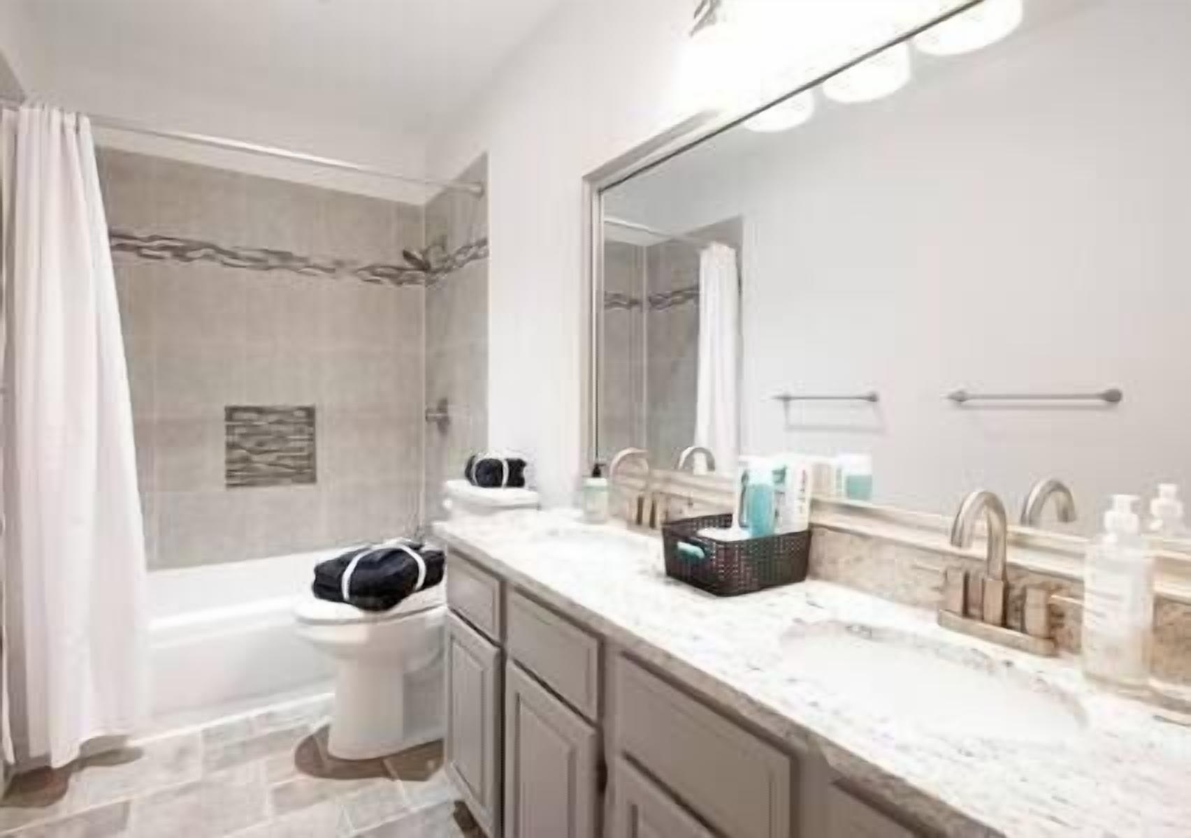 Un baño moderno con ducha, inodoro y tocador.