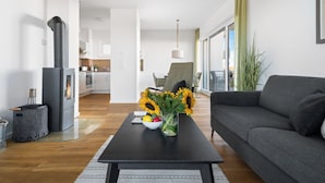 Una sala de estar moderna con un sofá, una mesa de centro de vidrio y una chimenea.