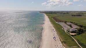An aerial view of a beach with a parking lot and buildings. - "Ocean Love": A vacation on the Baltic Sea, just a 3-minute walk from the beach, with a fireplace and a view of the sea (Olpenitz)