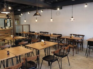 Enjoy meals in a stylish dining area with pendant lights, a minimalist clock, and framed pictures.