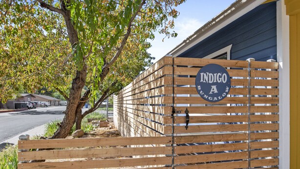 A wooden fence with a sign that reads "INDIGO A RUGBY."