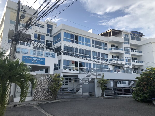 A multi-story building with a blue sign reading "LAURA MICHELLE XXIV". - Lexury Apartament (Santo Domingo)
