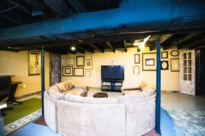 A circular seating area with a flat-screen TV in the center, surrounded by walls with framed pictures.