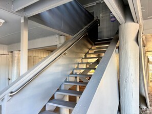 Una escalera metálica con barandilla que conduce a una plataforma.