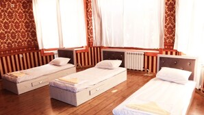 A room with three single beds, wooden flooring, and patterned wallpaper. - Ozbek Hotel (Andijan)