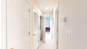 A hallway with white doors, a radiator, and a bed in the background. - Closest Shorehaven Unit to Cherry Grove Beach • 4-Min Walk • Sleeps 6 (North Myrtle Beach)