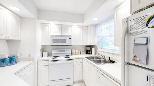 A modern kitchen with white cabinets, a microwave, stove, and refrigerator. - Closest Shorehaven Unit to Cherry Grove Beach • 4-Min Walk • Sleeps 6 (North Myrtle Beach)