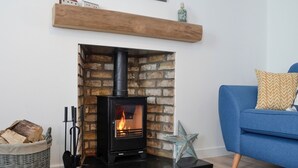 Una sala de estar moderna con un estufa de leña negra, un sofá azul y un adorno decorativo con forma de estrella.