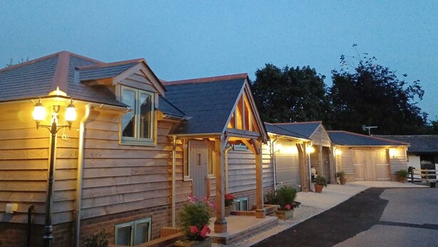 A row of wooden cabins with attached porches, each with a small porch light.