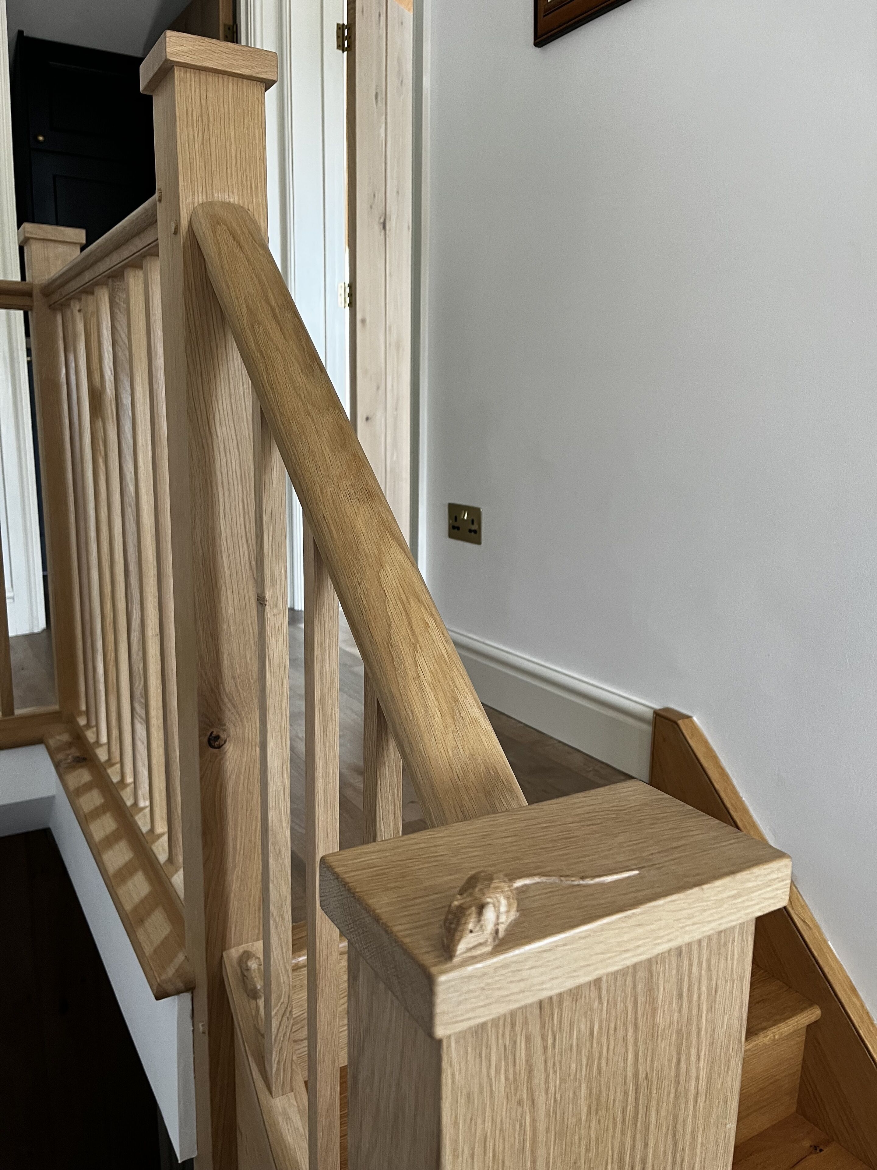 Un escalier en bois, doté d’une rampe et d’un palier.