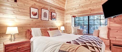 Relax in this inviting bedroom with a large bed, bedside tables, and a mounted television.