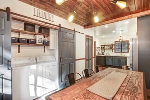 Un cuarto de lavandería con lavadora, tendederos y estantes para guardar.