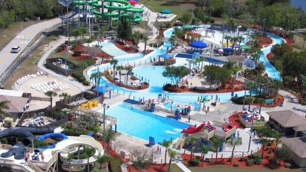 Een waterpark met een groot zwembad, verschillende glijbanen en een kronkelende waterglijbaan.