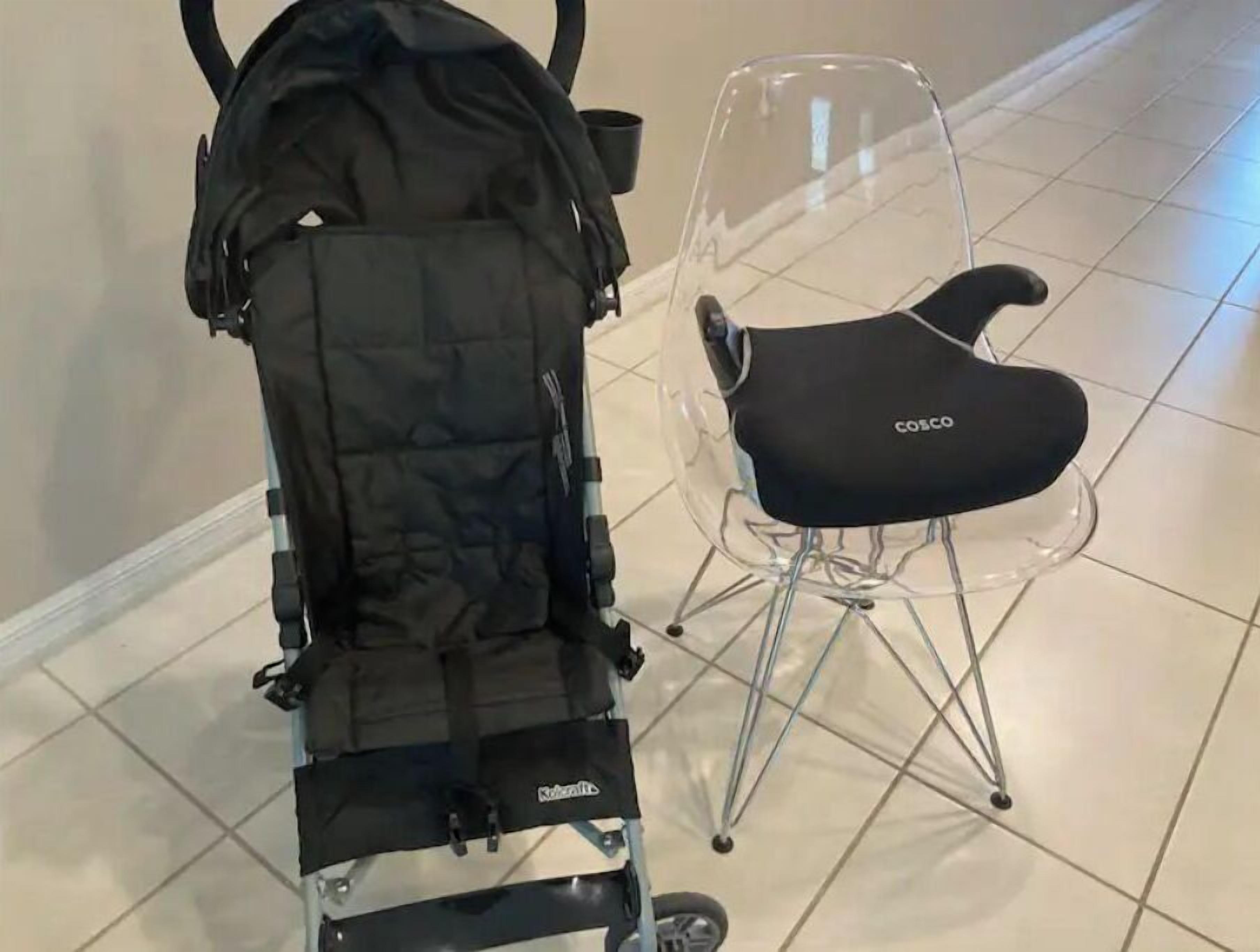 Une poussette dotée d’une housse noire et d’un siège en plastique transparent, placée à côté d’une chaise en plastique transparent avec un coussin noir.
