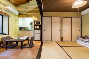 A traditional Japanese-style room with tatami flooring, a low table with chairs, a sofa, and sliding doors. - A 4minute walk from Keihan Shichijo Station the  / Kyoto Higashiyama Kyōto (Kyoto Higashiyama)