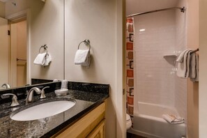 A bathroom with a sink, mirror, towel rack, and shower. - Westwind 306b Hotel Room in Lionshead Village (Vail)