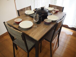 Una mesa de comedor con platos, vasos y una olla negra.