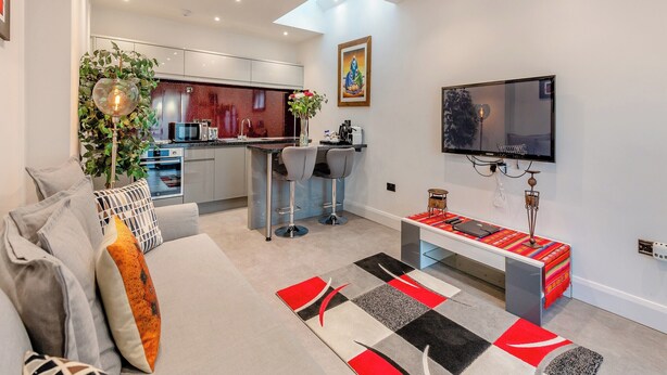 Ein modernes Apartment mit Küche, Essbereich und Wohnzimmer.