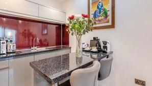 Eine moderne Küche mit einer Granitarbeitsplatte, Edelstahlgeräten und einem Essbereich mit Tisch und Stühlen.