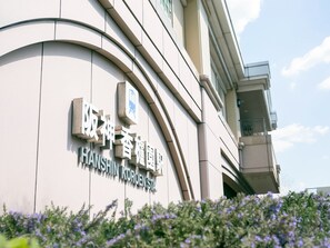 Un edificio con señalización en chino e inglés, que indica un lugar llamado "Hanshin Koroen St.".