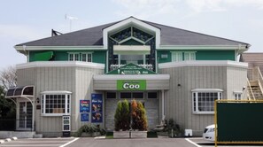 Welcome to Utility Hotel Coo, featuring a central entrance and two wings, with a flat roof and windows along the facade.