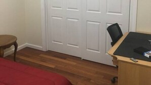 A bedroom with a bed, a desk with a chair, and a closet with two doors. - The couples home with free wifi (Schenectady)