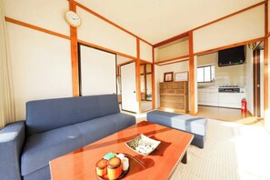 Relax in this stylish living room with a sofa, coffee table, and kitchen area.