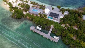 An aerial view of a private island with a large house, a swimming pool, and a dock. - Waterfront 4-Bedroom Home on Private Peninsula w/ Private Dock! (Elbow Cay)