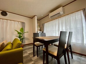 A dining area with a wooden table, chairs, and a plant.