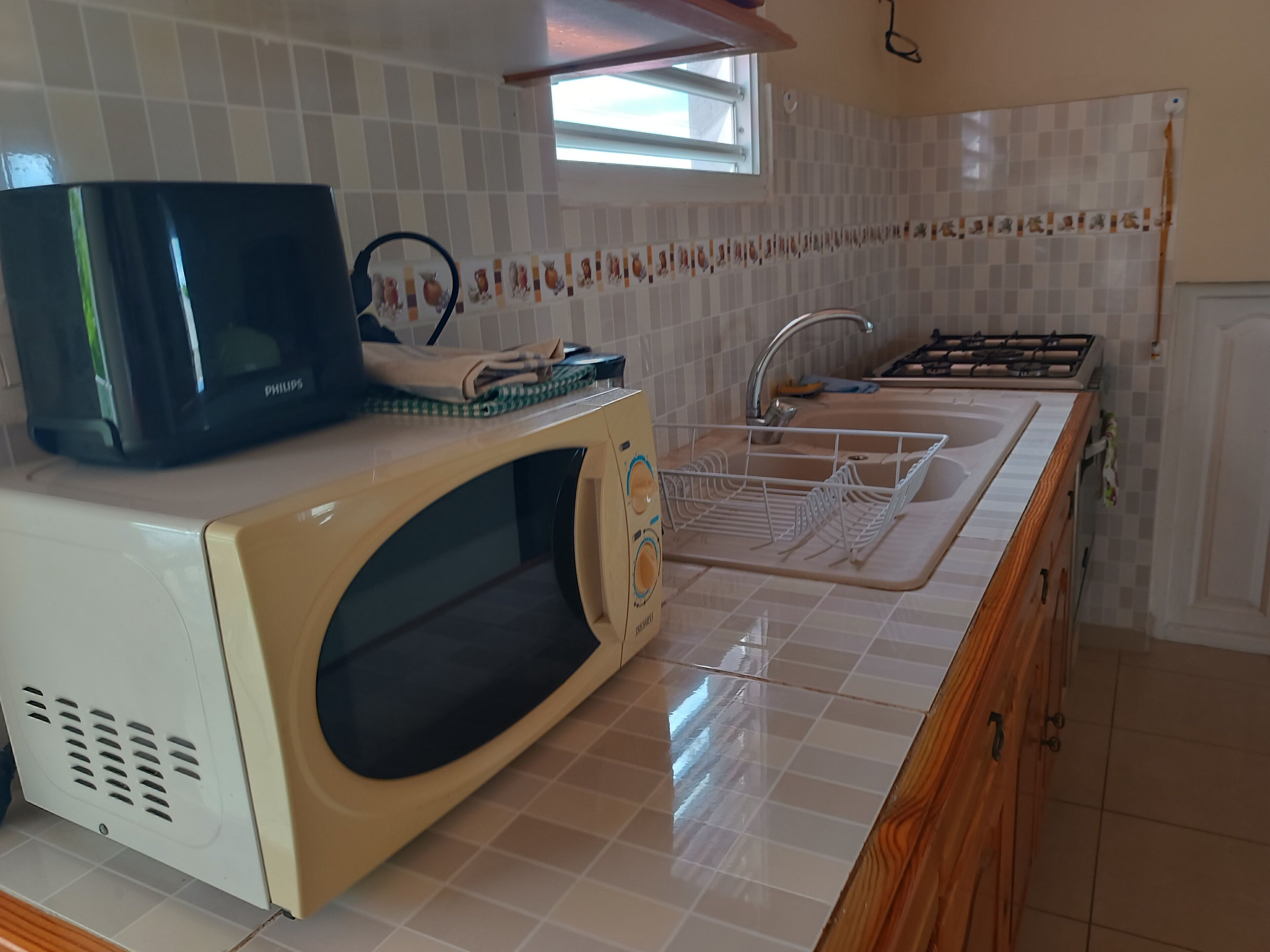 A kitchen with a microwave, sink, and stove.