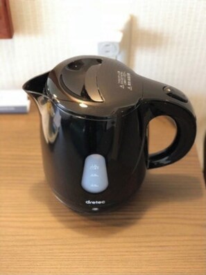 Electric kettle with digital display and power button.