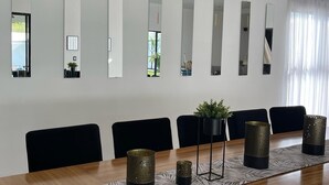 A conference room with a long table, six chairs, and six wall-mounted mirrors. - House Las Palmas (TICUMAN)