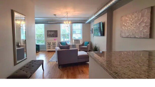 Ein modernes Wohnzimmer mit einer Couch, einer Bank und einem großen Wandbild.