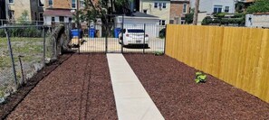 A pathway leading to a gated area with a fence and a yellow fence on the right.