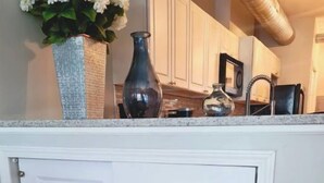A kitchen with white cabinetry, a countertop, and a wooden floor. - Medical District Gem III (Chicago)