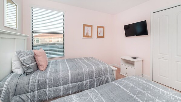 A bedroom with a bed, a nightstand, a TV, and a wardrobe.