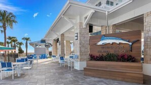 Entrada a un resort con un letrero que dice "Windsor Island Resort", mobiliario exterior y palmeras.