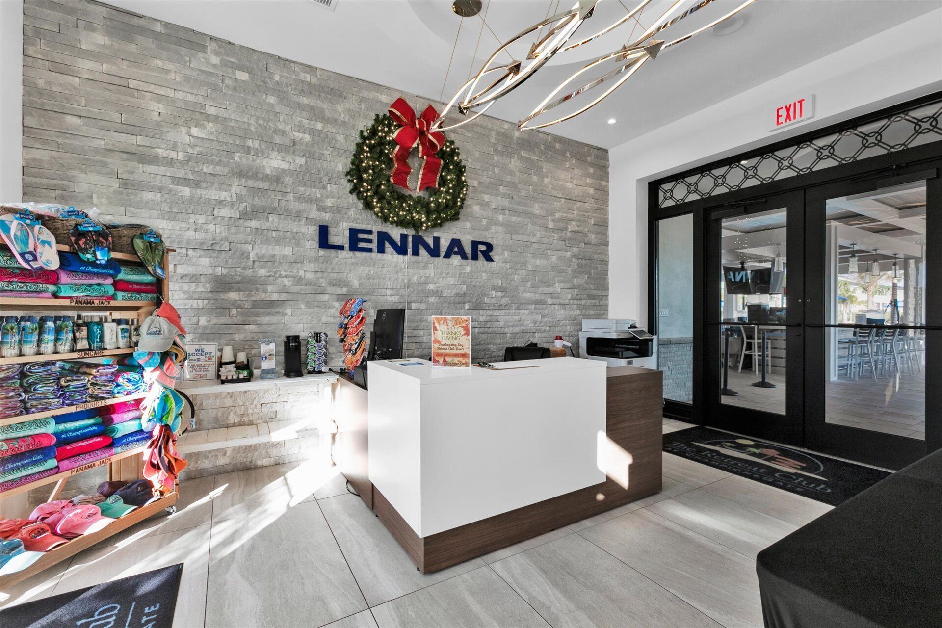 Ein Lennar Hotel-Empfangsbereich mit modernem Design, inklusive einer grauen Ziegelwand, eines Weihnachtsgestecks und einer Rezeption.