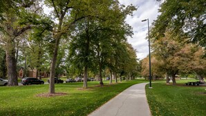 A tree-lined pathway with a sidewalk, benches, and parked cars. - Secluded in the City! New remodeled 2 bedroom near Berkeley Lake, pet friendly. (Denver)