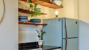 A kitchen with a blue refrigerator, wooden shelves, and a dining table with a bowl of fruit. - Gorgeous Carriage House close to USNA, walk to stadium, free parking,  pets+kids (Annapolis)