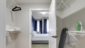Ein Hotelzimmer mit einem Bett, einem Kleiderschrank, einem Bügeleisen und einem Wäscheständer.