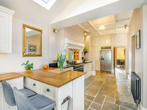 A modern kitchen with a wooden countertop, a stove, and a refrigerator.