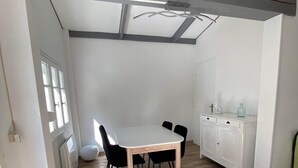A modern kitchen with a white countertop, black chairs, and a white cabinet.