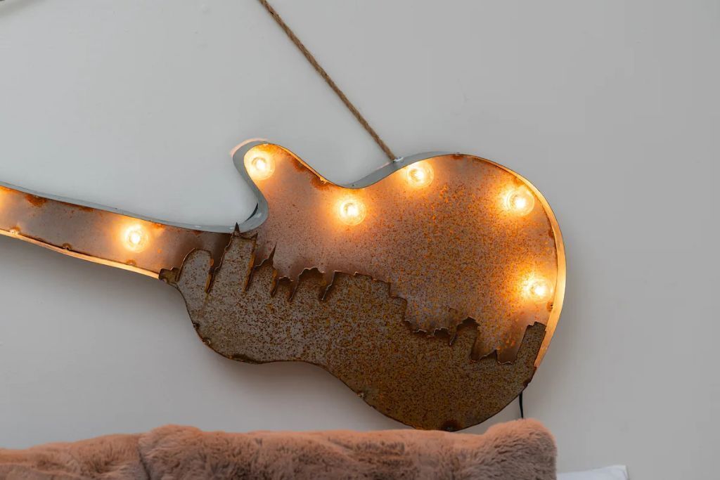 Un luminaire en forme de guitare, doté de plusieurs ampoules.